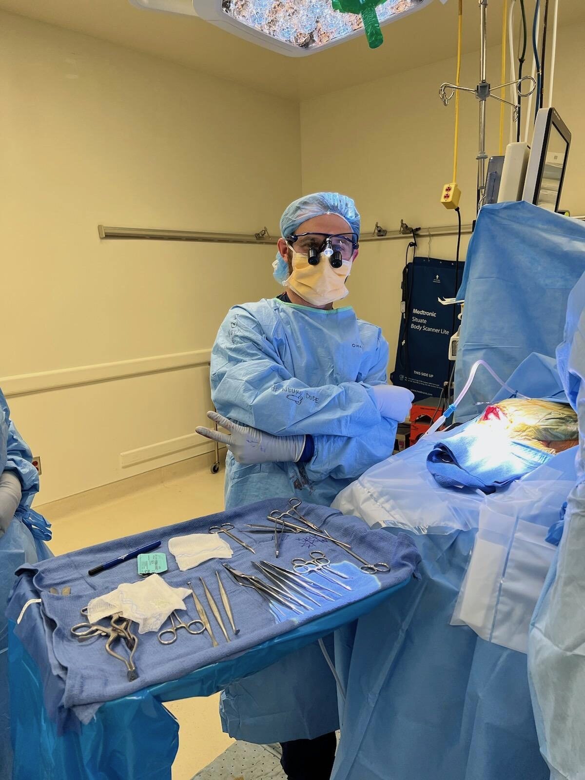 A surgical team member in sterile gown, mask and magnifying loupes.